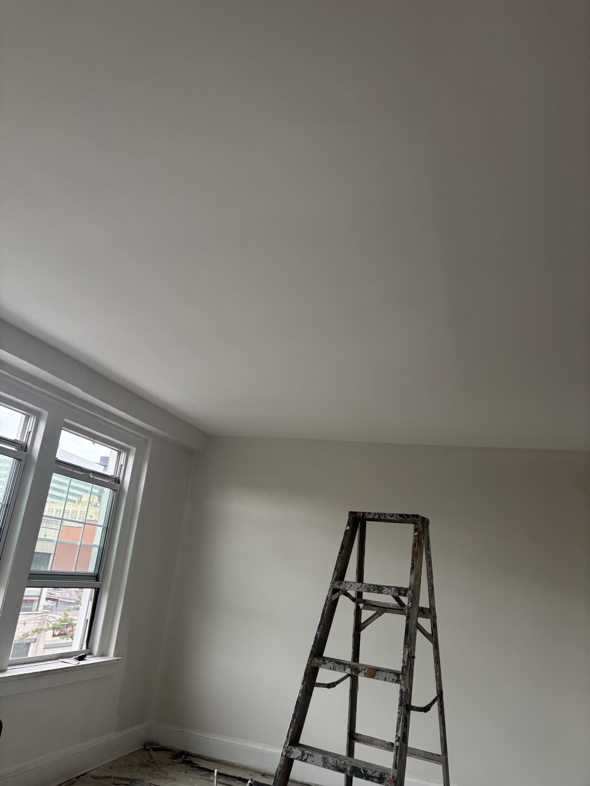 Ceiling after: smooth, freshly painted white ceiling and walls.