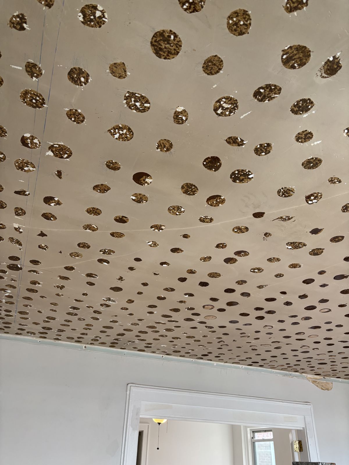 Ceiling before: dozens of round patches across the plaster.