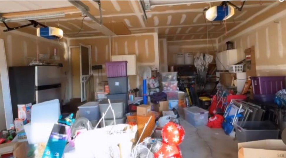 Two-car garage before: storage bins, boxes and toys covering the floor.