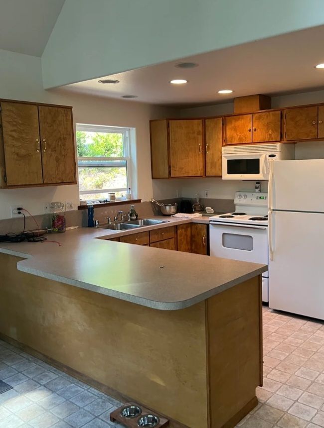 Kitchen before: honey-oak cabinets, white appliances and a laminate peninsula.